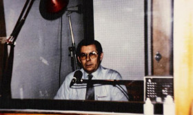 a man looking through the window of a sound studio