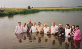a group of people standing waist-deep in a lake