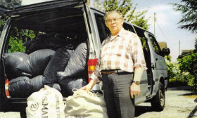 a man standing near large bags outside a van