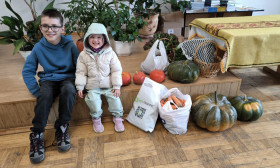 children sitting with bags of groceries and harvest decorations