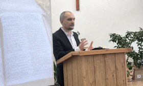 a man stands behind a lectern in a church sanctuary