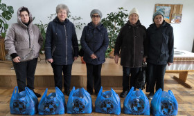 group of people standing with bags of products