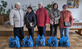 group of people standing with bags of products