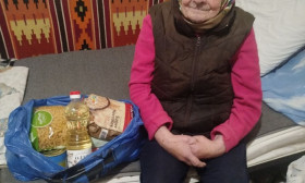 an elderly woman with a bag of groceries