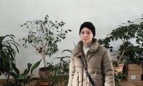 young person standing with a bag of products in the church auditorium