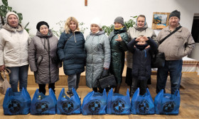 a group of people standing with grocery bags