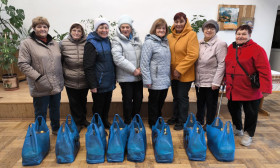 group of people standing with bags of groceries