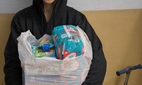 woman holding a bag of groceries and products