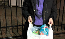 a young woman holding a bag of groceries