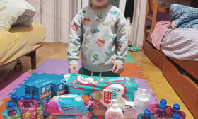 young boy laughing in front of a group of products