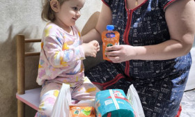 A mother and child receiving essential aid, including diapers and food, symbolizing hope and support for families in need.